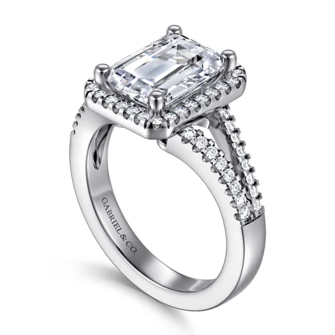 An emerald-cut halo engagement ring by Gabriel & Co. in white gold