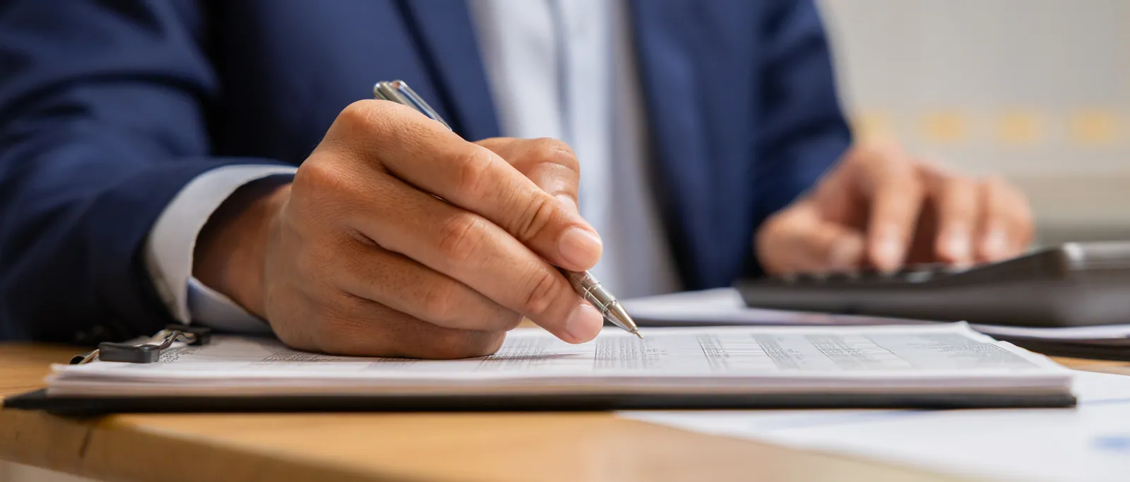 An appraiser writing the report by hand at the desk